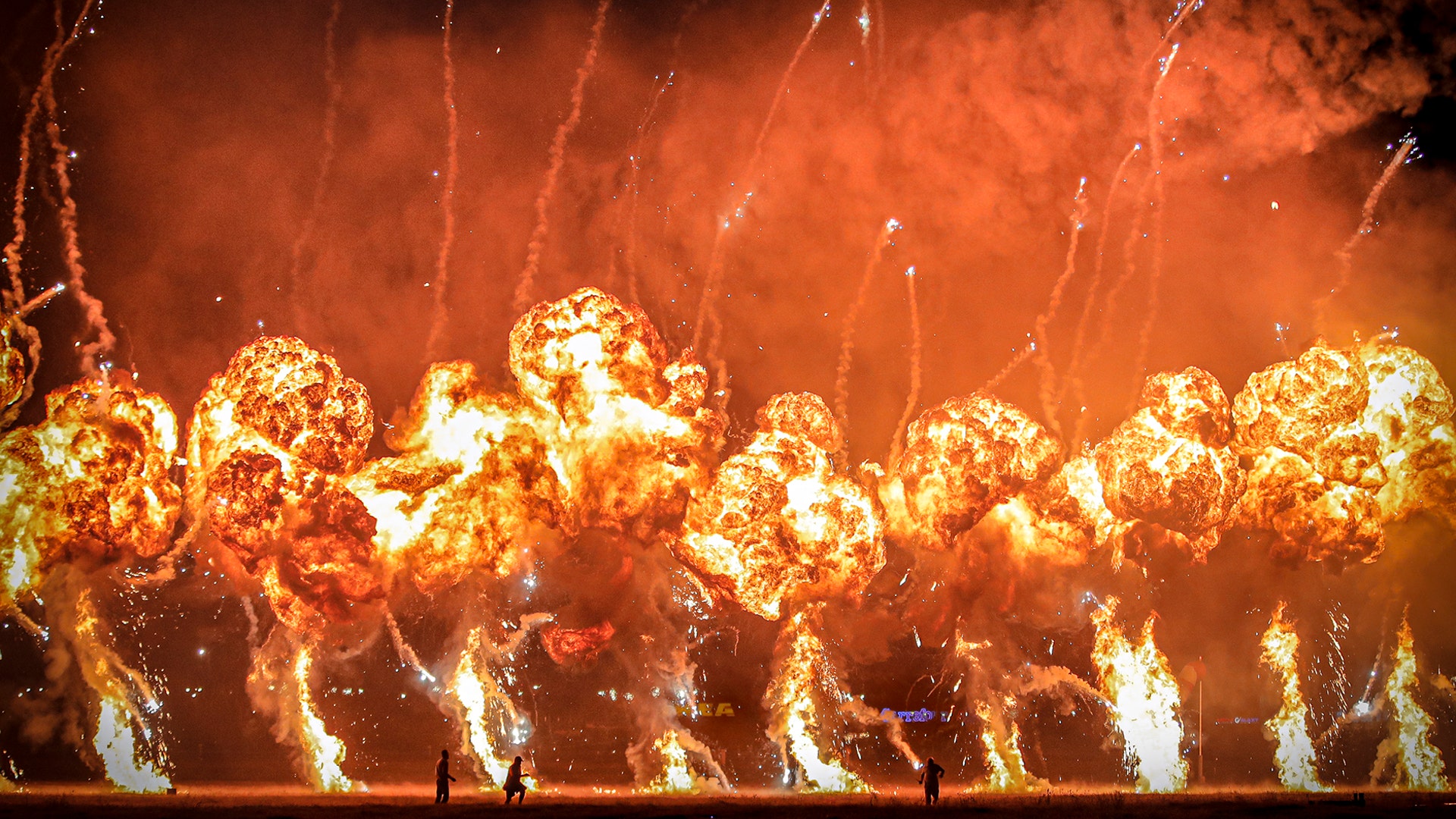 Technicians stand in front of exploding pyrotechnics during an international air show in Bucharest, Romania, Aug. 24, 2019. 