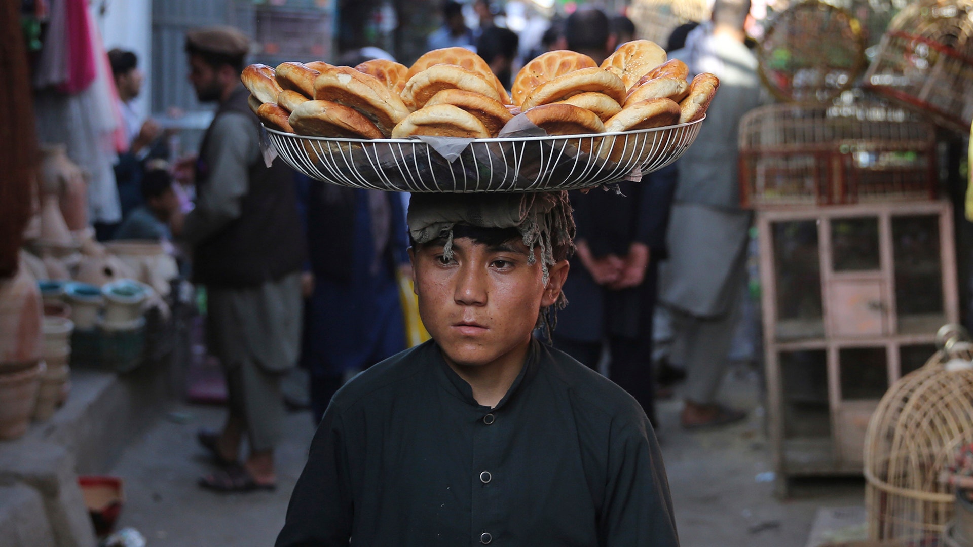 An Afghan boy carries bread for sale at a market in the old city of Kabul, Afghanistan, Aug. 1, 2019.