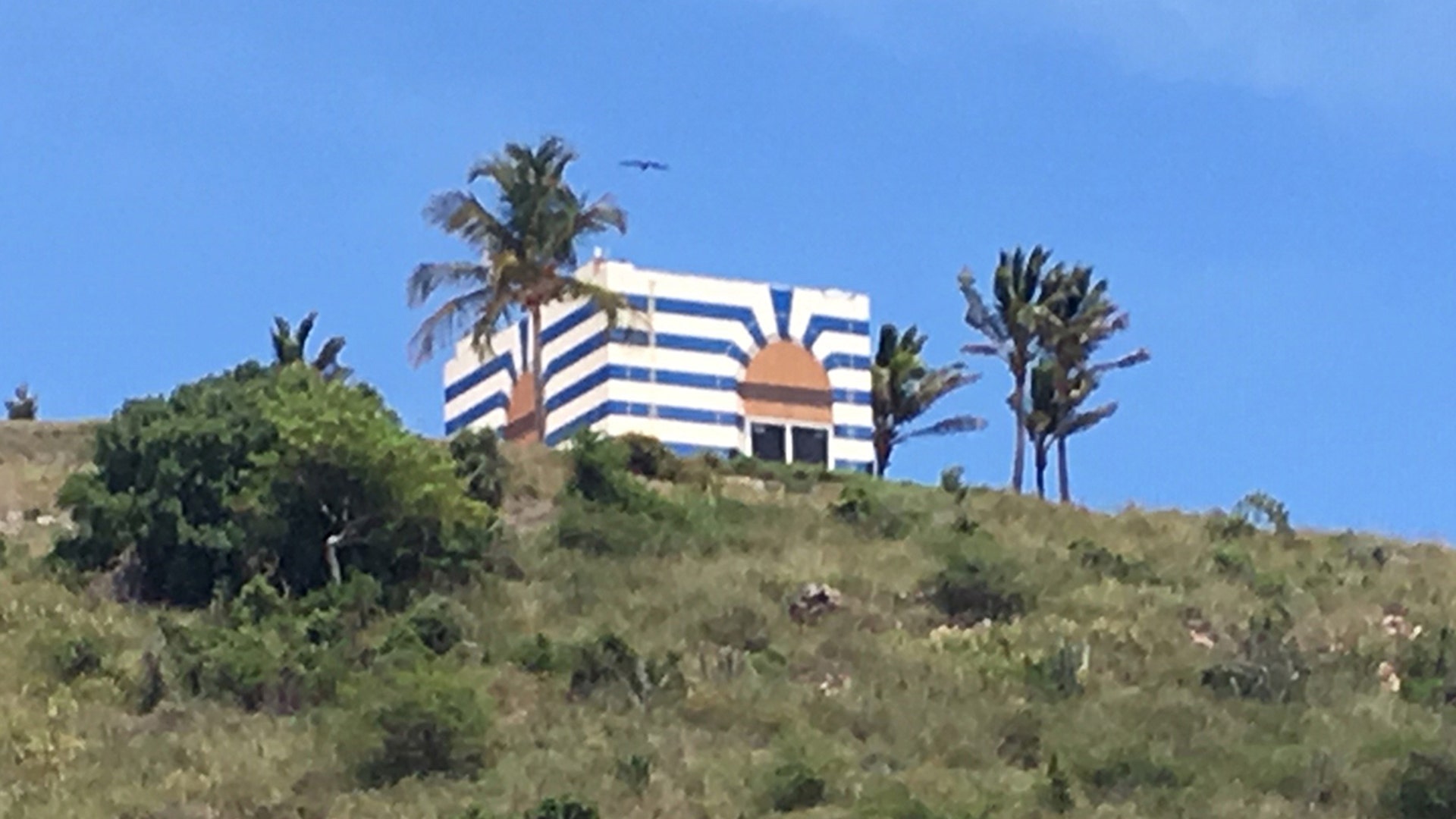 The blue and white stripped temple-like structure on Jeffrey Epstein's Little St. James Island was built to be a music room. The building once had a gold dome on it that blew away during a hurricane. 