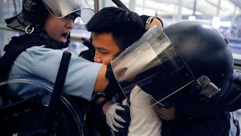 Hong Kong protesters clash with riot police armed with pepper spray at airport