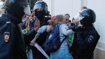 Russian police caught on camera punching female protester in stomach