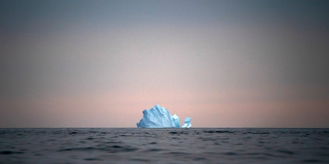 In this Aug. 15 photo, a large Iceberg floats away as the sun sets near Kulusuk, Greenland. (AP Photo/Felipe Dana)