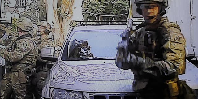 A security camera image provided by a neighbor who has requested not to be identified shows federal agents conducting a raid on the home of Paige A. Thompson in Seattle. (Associated Press)