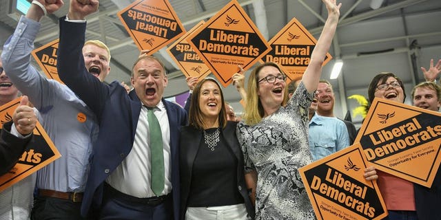 Liberal Democrats' Jane Dodds, centre, celebrates with supporters as she wins the seat in the Brecon and Radnorshire by-election at the Royal Welsh Showground in Llanelwedd, Builth Wells, Wales Friday, Aug. 2, 2019. After a first week in office that saw him booed in Scotland and berated in Belfast, British Prime Minister Boris Johnson was facing his first electoral test on Thursday, a special election that could see his Conservative government's working majority in Parliament cut to just one vote.