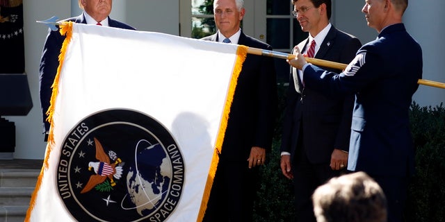 President Trump watches with Vice President Pence and Defense Secretary Mark Esper as the flag for U.S. Space Command is unfurled Thursday. (AP Photo/Carolyn Kaster)