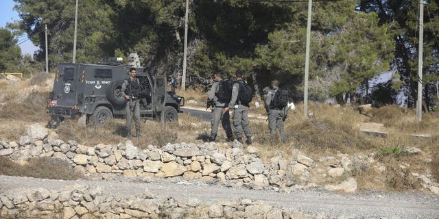 Israeli troops secure the area where a body of a soldier with stab wounds was found near Gush Etzion settlement in the West Bank, Thursday, Aug, 8, 2019.