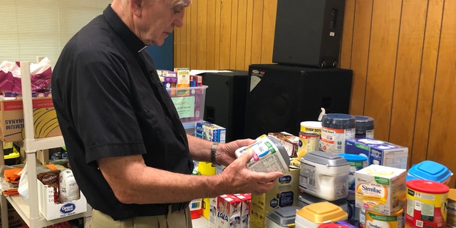 Father Mike O'Brien looks through donations for families affected by ICE raids in Mississippi that targeted chicken processing plants. O'Brien said his parish is acting as an emergency crisis center to keep families afloat. (Fox News/Charles Watson