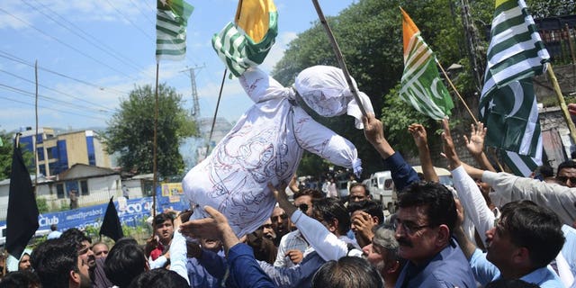 Pakistani Kashmiris carry an effigy of Indian Premier Narendra Modi during an anti-Indian protest in Muzaffarabad, capital of Pakistani Kashmir, Thursday, Aug. 8, 2019. Pakistan's federal minister for railways said Thursday that Islamabad has suspended a key train service with neighboring India over change in Kashmir's special status by New Delhi.