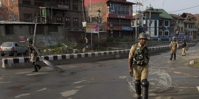 Indian Paramilitary soldiers drag barbwire as they prepare to impose curfew in Srinagar, Indian controlled Kashmir, Wednesday, Aug. 7, 2019. Authorities in Hindu-majority India clamped a complete shutdown on Kashmir as they scrapped the Muslim-majority state's special status, including exclusive hereditary rights and a separate constitution, and divided it into two territories.
