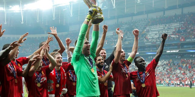 Liverpool's goalkeeper Adrian lifts up the trophy as he celebrates with players after winning the UEFA Super Cup soccer match between Liverpool and Chelsea, in Besiktas Park.