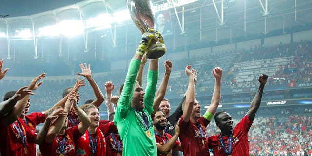 Liverpool's goalkeeper Adrian lifts up the trophy as he celebrates with players after winning the UEFA Super Cup soccer match between Liverpool and Chelsea, in Besiktas Park.