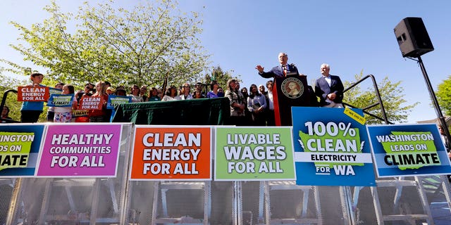 Washington Gov. Jay Inslee, second right, addresses the crowd before signing climate protection legislation in Seattle on May 7, 2019. (AP Photo/Elaine Thompson, File)