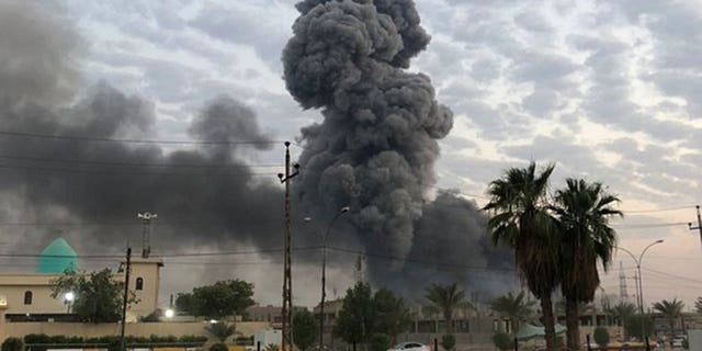 In this Monday, Aug. 12, 2019 file photo, plumes of smoke rise after an explosion at a military base southwest of Baghdad, Iraq. A fact-finding committee appointed by the Iraqi government to investigate a massive munitions depot explosion near the capital Baghdad has concluded that the blast was the result of a drone strike.