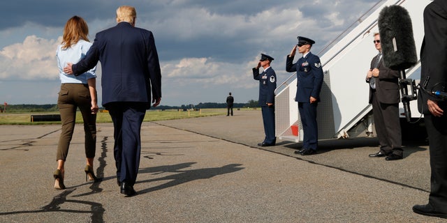 President Donald Trump, with first lady Melania Trump, walks back to Airs Force One after speaking to the media before boarding Air Force One in Morristown, N.J., Sunday, Aug. 4, 2019. (AP Photo/Jacquelyn Martin)