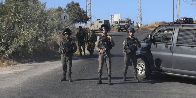 Israeli troops secure the area where a body of a soldier with stab wounds was found near Gush Etzion settlement in the West Bank, Thursday, Aug, 8, 2019.