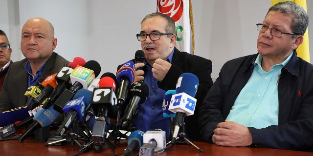 Flanked by Carlos Lozada, left, and Pablo Catatumbo, right, Rodrigo Londono who had been the Revolutionary Armed Forces of Colombia, FARC, top military commander and now heads its legal political party, speaks during a press conference in Bogota, Colombia, Thursday, Aug. 29, 2019.