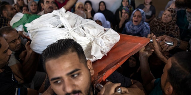 Mourners carrying the body of Palestinian Hamas militant Mohammad Abu Namous out of the family home during his funeral Sunday.
