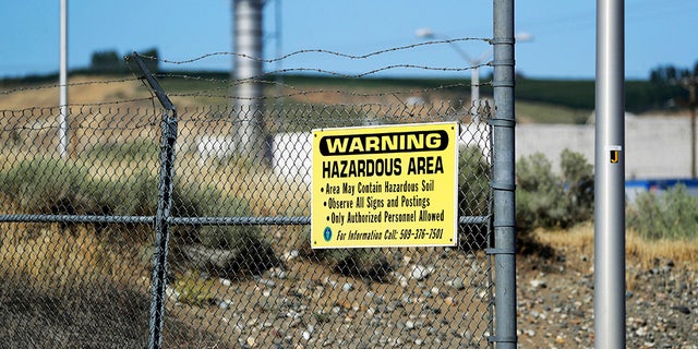 A sign at the Hanford Nuclear Reservation warning of possible hazards in the soil there along the Columbia River near Richland, Wash. (AP Photo/Elaine Thompson)