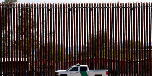 FILE - In this April 5, 2019, file photo, a U.S. Customs and Border Protection vehicle sits near the wall as President Donald Trump visits a new section of the border wall with Mexico in El Centro, Calif. The Supreme Court has cleared the way for the Trump administration to tap Pentagon funds to build sections of a border wall with Mexico. (AP Photo/Jacquelyn Martin, File)