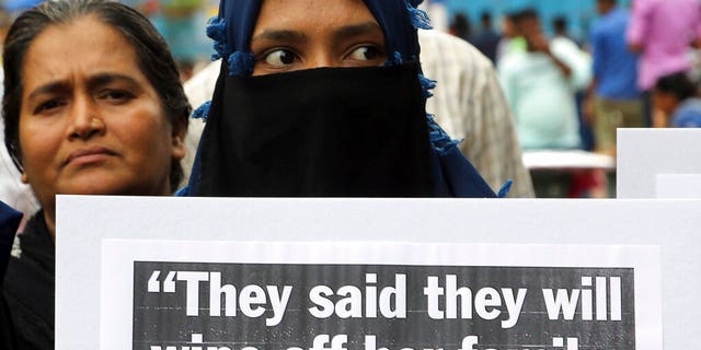 An Indian woman holds a placard during a protest to condemn a deadly car crash that left a woman who accused a politician of rape in critical condition, in Mumbai, India, on Thursday.