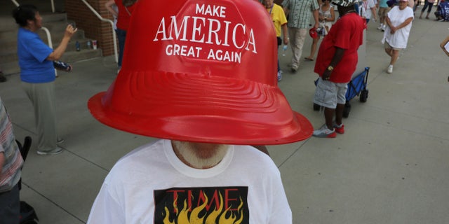 Robert Morris, of Jasper, Tenn., wears a giant hat as he waits in line to enter a rally by President Donald Trump Thursday, Aug. 1, 2019, in Cincinnati. (AP Photo/Gary Landers)