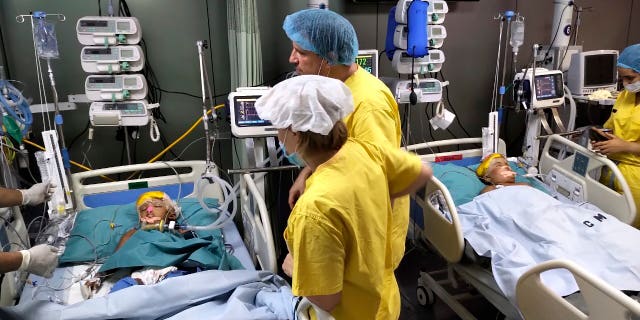 In this Aug. 1, 2019 photo provided by Action for Defenceless People Foundation, Rabeya and Rukaya lie in beds under supervision by Hungarian anesthesiologists, in a military hospital in Dhaka, Bangladesh. The twins, who were born conjoined at the head, have been successfully separated by a medical team led by 35 Hungarian doctors and were in a stable condition after the 30-hour procedure ended Aug. 2. (Action for Defenceless People Foundation via AP)