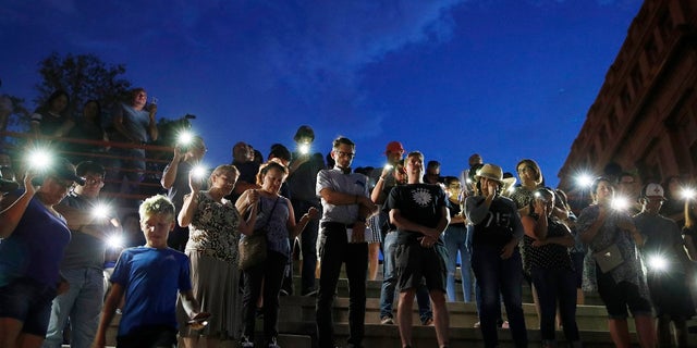 People attend a vigil for victims of the shooting Saturday, Aug. 3, 2019, in El Paso, Texas. A young gunman opened fire in an El Paso, Texas, shopping area during the busy back-to-school season, leaving multiple people dead and more than two dozen injured. (AP Photo/John Locher)