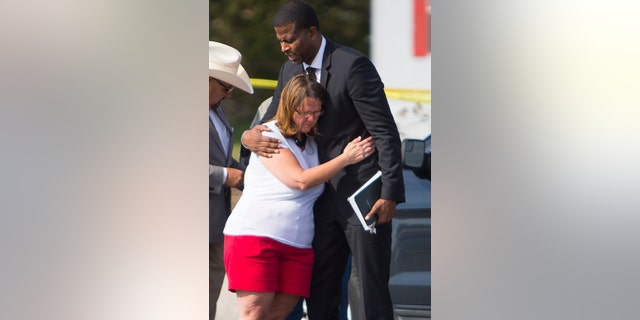 FILE - In this Nov. 6, 2017, file photo Sherri Pomeroy, wife of Pastor Frank Pomeroy, who lost their daughter in a mass shooting at the First Baptist Church of Sutherland Springs, Texas, hugs Pastor Dimas Salaberrios before a news conference in Sutherland Springs. Pomeroy sought to boost his followers' resolve with upbeat remarks at Sunday's service. He urged them not to live "in a spirit of fear. (Mark Mulligan/Houston Chronicle via AP, File)