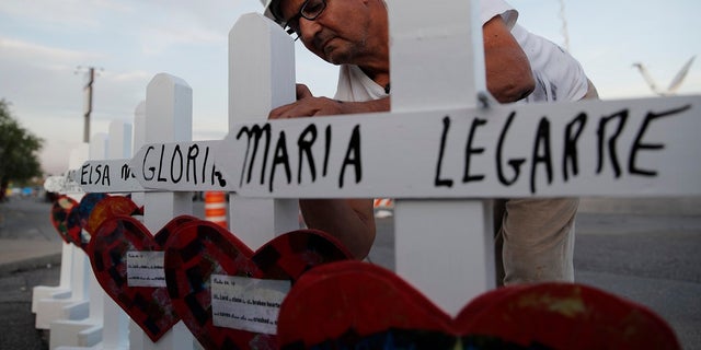 Greg Zanis prepares crosses to place at a makeshift memorial for victims of a mass shooting at a shopping complex Monday in El Paso, Texas. (AP Photo/John Locher)