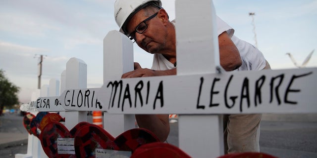 Greg Zanis prepares crosses to place at a makeshift memorial for victims of a mass shooting at a shopping complex Monday in El Paso, Texas. (AP Photo/John Locher)