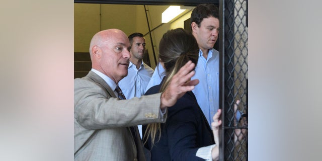 In this 2018 photo, New Orleans Police Department Officers John Galman, second left, and Spencer Sutton, right, arrive in New Orleans Municipal Court for a bail hearing with their lawyers. (Matthew Hinton/The Times-Picayune/The New Orleans Advocate via AP)