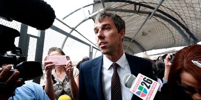 Beto O'Rourke surrounded by reporters as he walks on an international bridge to cross into Ciudad Juarez, Mexico, on Aug. 8. (AP Photo/Christian Chavez)