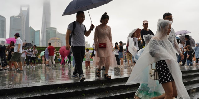 Visitors leave from the bund as Typhoon Lekima approaches in Shanghai Saturday, Aug. 10, 2019. Typhoon Lekima has struck China's coast south of Shanghai, knocking down trees and forcing airlines to cancel flights.