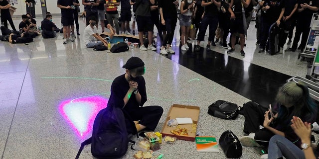 A protester makes a birthday wish during a protest at the Hong Kong International Airport, Monday, Aug. 12, 2019. One of the world's busiest airports canceled all flights after thousands of Hong Kong pro-democracy protesters crowded into the main terminal Monday afternoon. (AP Photo/Kin Cheung)