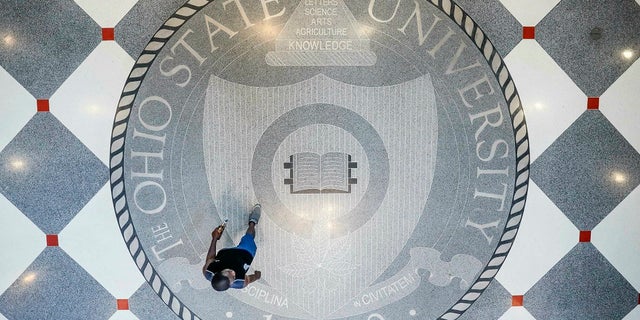 In this May 18, 2019 file photo, pedestrians pass through Ohio State University's student union in Columbus, Ohio. Ohio State University wants to trademark the word "The" when used as part of the school’s name on university merchandise. (AP Photo/John Minchillo)
