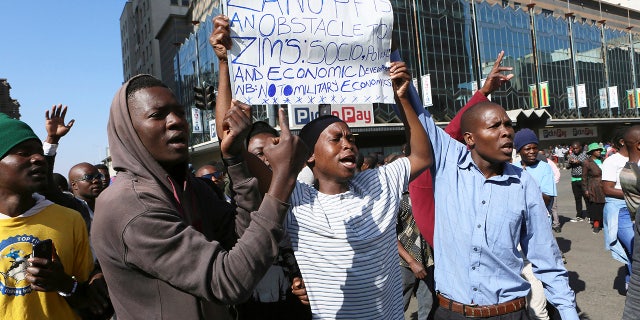 Người biểu tình tụ tập trên một con phố ở Harare, Thứ Sáu, ngày 16 tháng 8 năm 2019. Phong trào đối lập chính cho đảng Thay đổi Dân chủ cho biết họ sẽ tiến hành các cuộc biểu tình "hòa bình" bắt đầu từ tuần này để cố gắng buộc Tổng thống Emmerson Mnangagwa thành lập một cơ quan chuyển tiếp để giải quyết các vấn đề kinh tế và tổ chức các cuộc bầu cử đáng tin cậy. (Ảnh AP / Tsvangirayi Mukwazhi)