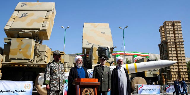 Iran's President Hassan Rouhani, second left, speaks during a ceremony to unveil the Iran-made Bavar-373, a long-range surface-to-air missile system at an undisclosed location in Iran, Thursday, Aug. 22, 2019.