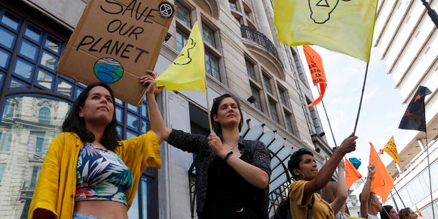 Extinction Rebellion activists protest outside the Brazilian Embassy in London, Friday, Aug. 23, 2019, to call on Brazil's President Jair Bolsonaro to act to protect the Amazon rainforest. 