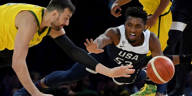 Australia's Andrew Bogut, left and United States Donovan Mitchell, right compete for the ball during their exhibition basketball game in Melbourne on Saturday. (AP Photo/Andy Brownbill)