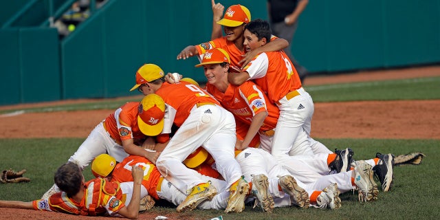 River Ridge, Louisiana's Stan Wilts hugs Patton Spadrero (6) on top of the pile as they celebrate their 8-0 win over Curacao in the South Williams World Cup game at South Williamsport, PA, Sunday, August 25, 2019 (AP Photo / Tom E. Puskar)