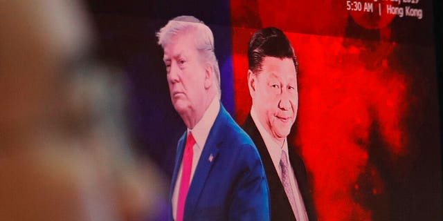 A computer screen shows images of Chinese President Xi Jinping, right, and U.S. President Donald Trump as a currency trader works at the foreign exchange dealing room of the KEB Hana Bank headquarters in Seoul. (AP Photo/Ahn Young-joon)