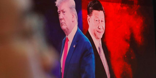 A computer screen shows images of Chinese President Xi Jinping, right, and U.S. President Donald Trump as a currency trader works at the foreign exchange dealing room of the KEB Hana Bank headquarters in Seoul. (AP Photo/Ahn Young-joon)