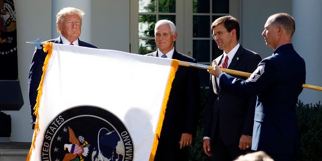 President Donald Trump, Vice President Mike Pence and Defense Secretary Mark Esper watch as the flag for U.S. Space Command was unfurled in 2019. (AP Photo/Carolyn Kaster)