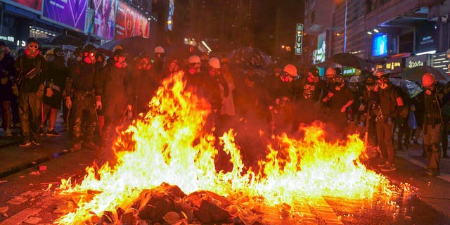 Protesters stand near burning items during a pro-democracy protest in causeway bay, Hong Kong, Saturday, Aug. 31, 2019.