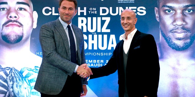 Boxing promoters Eddie Hearn and managing partner of Skill Challenge Entertainment Omar Khalil shake hands, during a press conference at The Savoy Hotel, London, Monday, Aug. 12, 2019. Anthony Joshua's promoters say his world heavyweight title rematch against Andy Ruiz Jr. will take place in Diriyah, Saudi Arabia, on Dec. 7. (Ian Walton/PA via AP)