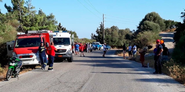Authorities and residents gather near the location where police said the body of Cyprus-based astrophysicist Natalie Christopher, 35, was found in a 65-foot deep ravine, in Faros village on the Greek island of Ikaria, Wednesday, Aug. 7, 2019.