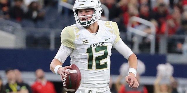 FILE - In this Nov. 24, 2018, file photo, Baylor quarterback Charlie Brewer scrambles out of the pocket before throwing a pass in the first half of an NCAA college football game against Texas Tech in Arlington, Texas. (Jerry Larson/Waco Tribune-Herald via AP, file)