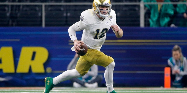 FILE - In this Dec. 29, 2018, file photo, Notre Dame quarterback Ian Book (12) runs the ball against Clemson during the NCAA Cotton Bowl semifinal playoff football game, in Arlington, Texas. Upon his return to campus last winter, Book immediately worked on his leadership skills and also making the difficult and tight downfield passes. Book was rewarded when he was named one of the team’s seven captains. (AP Photo/Michael Ainsworth, File)