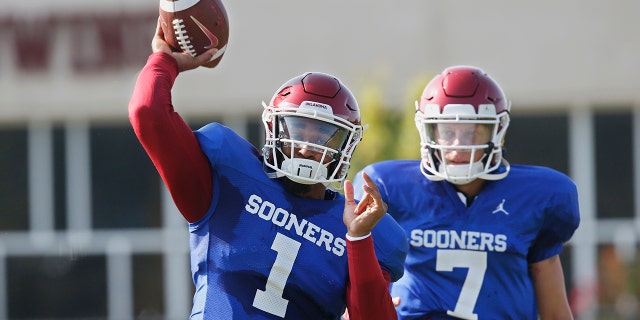 FILE - In this Monday, Aug. 5, 2019, file photo, Oklahoma quarterback Jalen Hurts (1) throws as quarterback Spencer Rattler watches during the NCAA college football team's practice in Norman, Okla. Oklahoma coach Lincoln Riley has chosen Hurts as his starting quarterback for the Sept. 1 season opener against Houston over Rattler and Tanner Mordecai. (AP Photo/Sue Ogrocki, File)