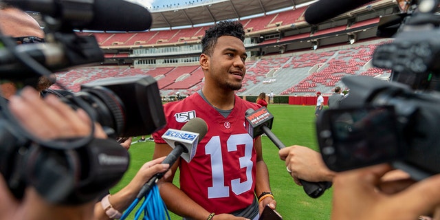FILE - In this Aug. 3, 2019, file photo, Alabama quarterback Tua Tagovailoa (13) talks with the media prior to Alabama's fall camp fan-day college football scrimmage, in Tuscaloosa, Ala. Two constants remain at Alabama: coach Nick Saban and championship expectations. Now, just add in a Heisman Trophy candidate at quarterback and a national title game humbling that provided ample offseason motivation. (AP Photo/Vasha Hunt, File)